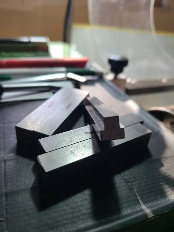 Several longer C45 profiled blanks before being cut into individual T-nuts