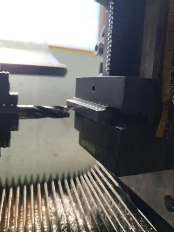 mounted adapter plate on the lathe's vertical milling slide with endmill in the chuck and milling operation